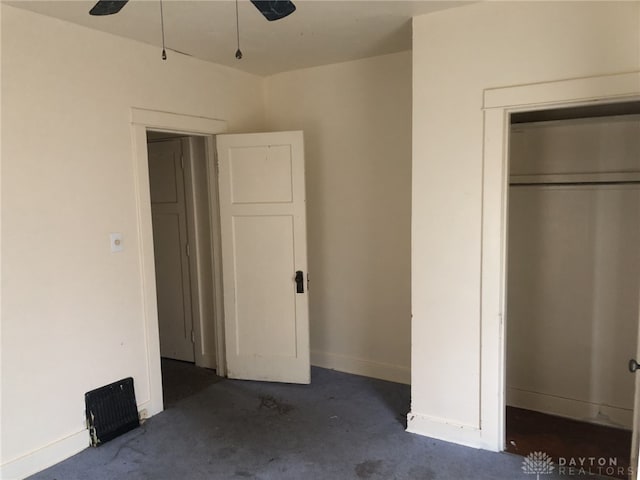 unfurnished bedroom with baseboards, unfinished concrete flooring, and a closet