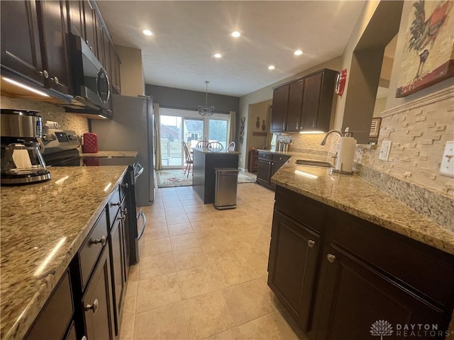 kitchen featuring appliances with stainless steel finishes, recessed lighting, a sink, and light stone countertops