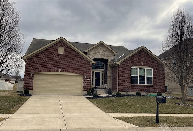 view of front facade with a garage, brick siding, concrete driveway, stone siding, and a front yard