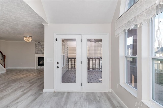 entryway featuring vaulted ceiling, french doors, and wood finished floors