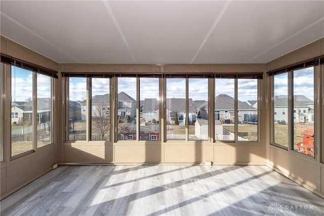 unfurnished sunroom featuring plenty of natural light and a residential view