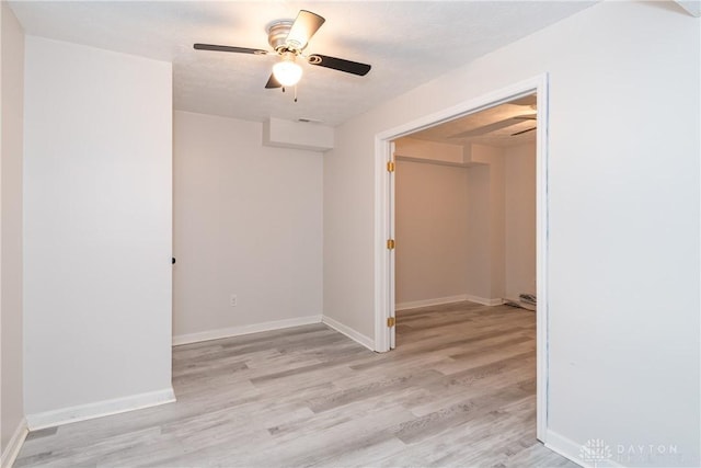 unfurnished room featuring light wood finished floors, baseboards, and a ceiling fan