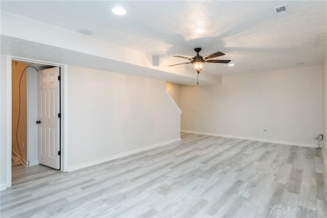 spare room with light wood-style floors, visible vents, baseboards, and a ceiling fan