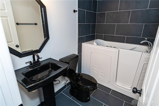 bathroom with toilet, tile patterned flooring, and a bath