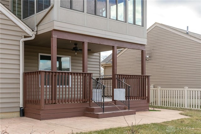 entrance to property with a ceiling fan and fence