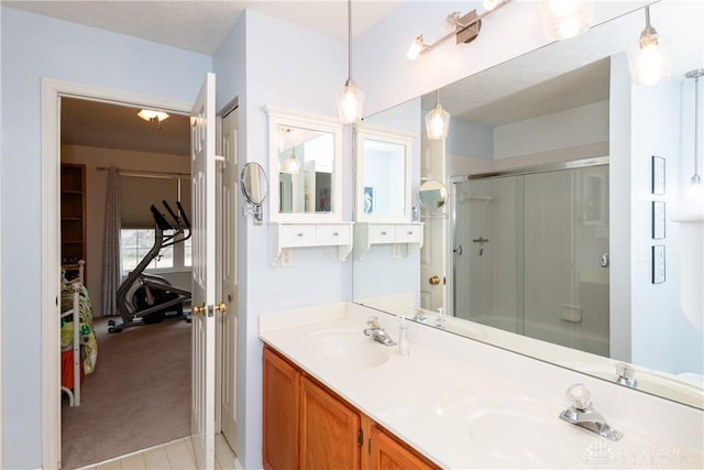 full bathroom featuring double vanity, a shower stall, and a sink