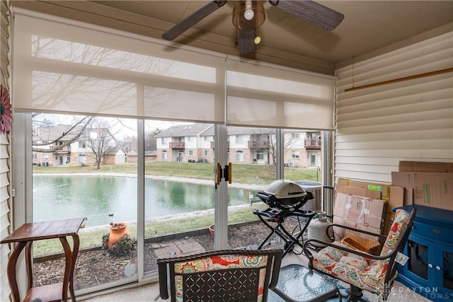 sunroom / solarium featuring a ceiling fan, a residential view, and plenty of natural light