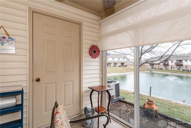 sunroom / solarium featuring a water view