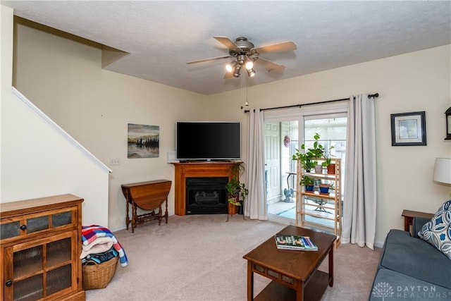 living room with carpet, a fireplace, and ceiling fan