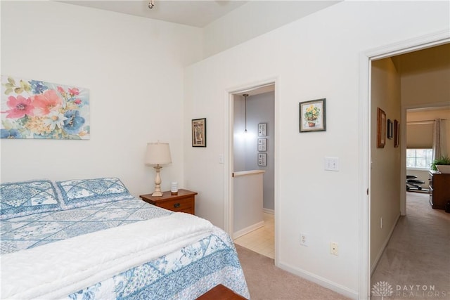 bedroom with light carpet and baseboards