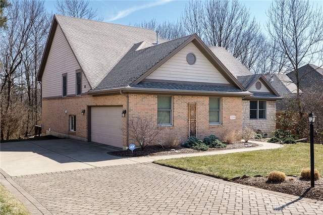 view of front facade featuring brick siding, decorative driveway, an attached garage, and a shingled roof