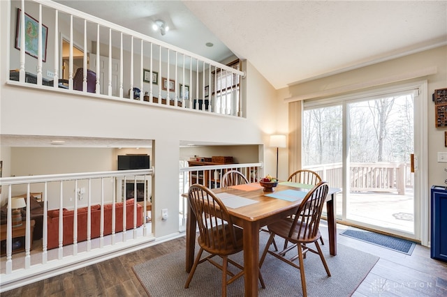 dining room featuring a towering ceiling and wood finished floors