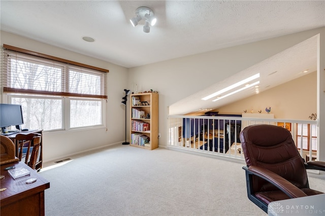 office featuring a textured ceiling, visible vents, vaulted ceiling, and carpet flooring