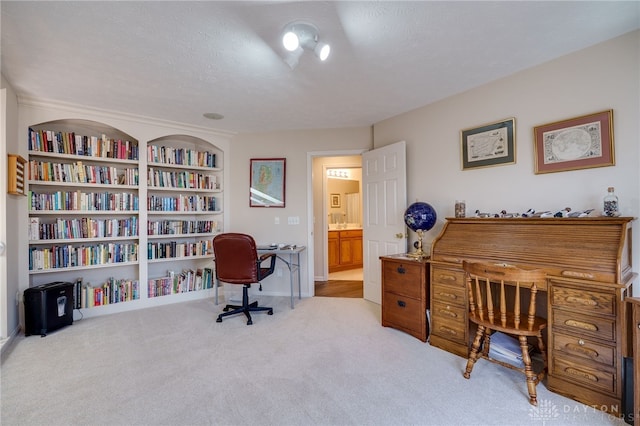 office area with carpet floors, a textured ceiling, and built in features