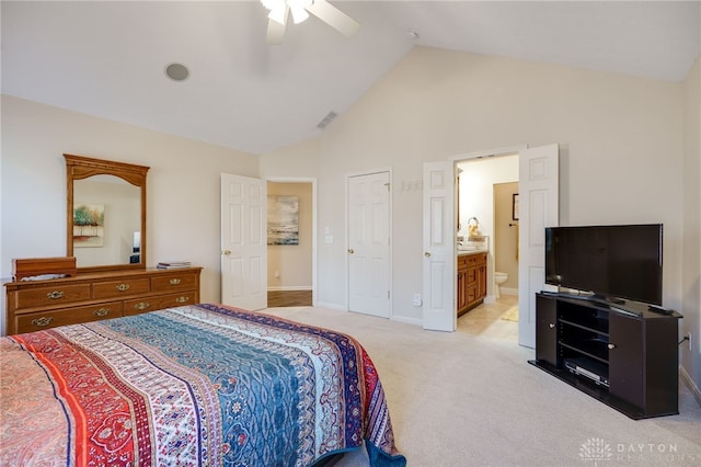 bedroom featuring high vaulted ceiling, light colored carpet, a ceiling fan, visible vents, and ensuite bath