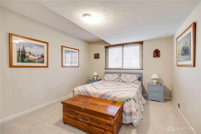 carpeted bedroom featuring a textured ceiling and baseboards