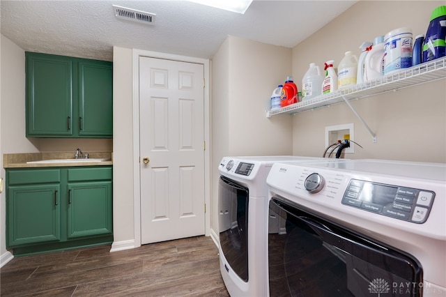 clothes washing area featuring cabinet space, visible vents, dark wood-type flooring, a textured ceiling, and independent washer and dryer