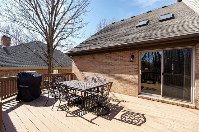 deck with grilling area and outdoor dining space