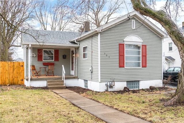 view of front of home featuring a porch, a front yard, fence, and a chimney