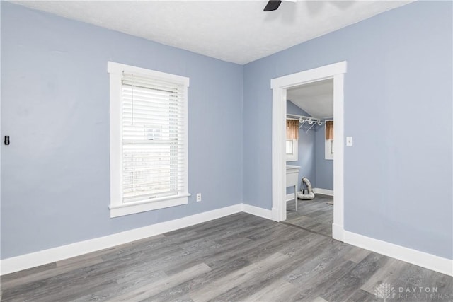 spare room with a ceiling fan, baseboards, and wood finished floors