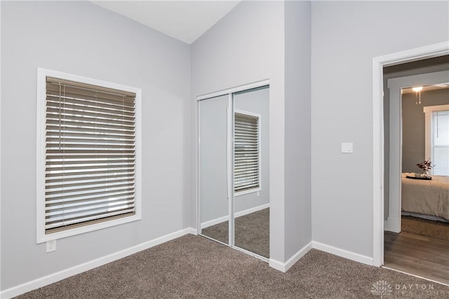 unfurnished bedroom featuring a closet, carpet flooring, and baseboards