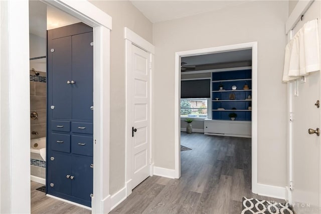 corridor with wood finished floors and baseboards