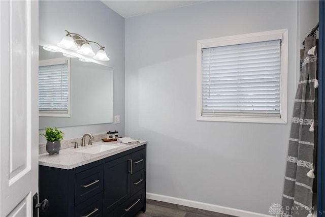 bathroom featuring wood finished floors, vanity, and baseboards