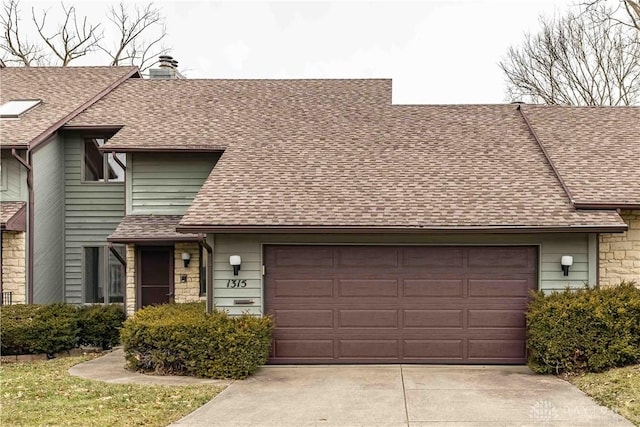 multi unit property featuring a chimney, a shingled roof, concrete driveway, an attached garage, and stone siding