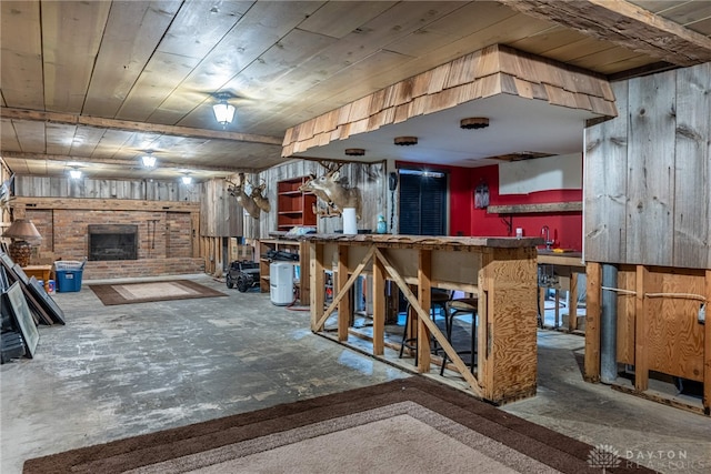 interior space with a brick fireplace, wooden ceiling, and wooden walls