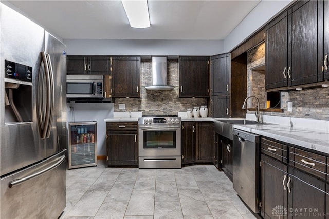 kitchen with wine cooler, stainless steel appliances, dark brown cabinets, wall chimney range hood, and backsplash