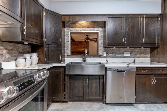 kitchen with tasteful backsplash, light countertops, appliances with stainless steel finishes, a sink, and dark brown cabinets