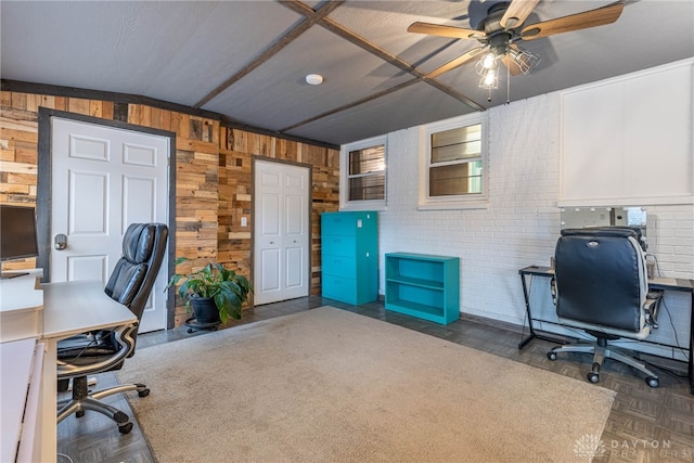 office area featuring a ceiling fan and wood walls