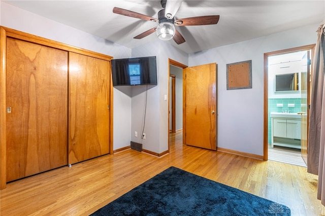 unfurnished bedroom featuring connected bathroom, a ceiling fan, baseboards, a closet, and light wood finished floors