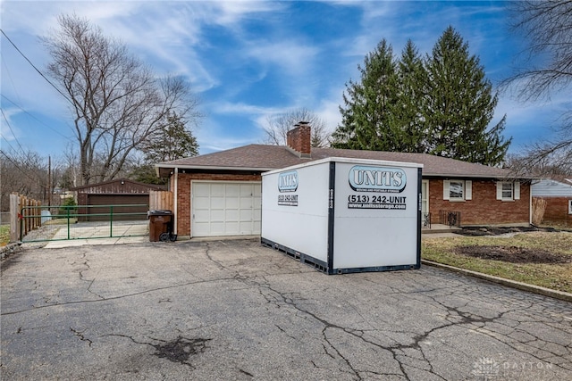 garage with fence and driveway