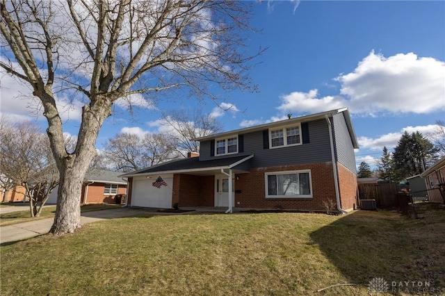 traditional-style house featuring a garage, driveway, brick siding, fence, and a front yard