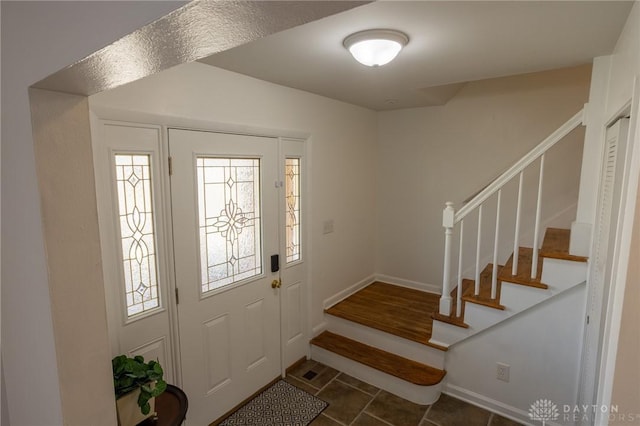 entryway with tile patterned flooring, stairway, and baseboards