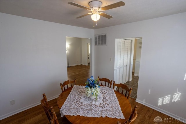 dining room with a ceiling fan, visible vents, baseboards, and wood finished floors