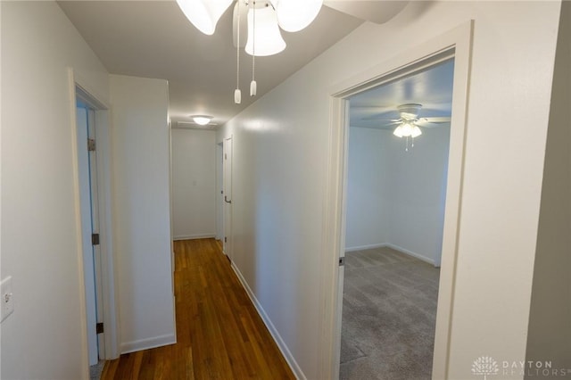 corridor featuring wood finished floors and baseboards