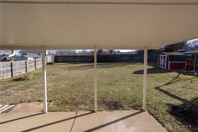 view of yard with an outbuilding, a storage shed, a patio area, and a fenced backyard