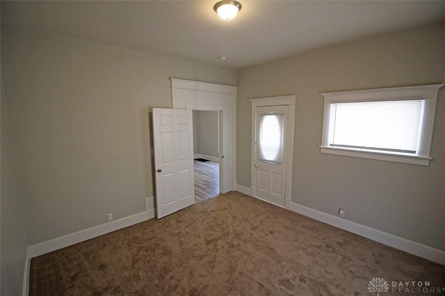 entrance foyer featuring carpet floors and baseboards