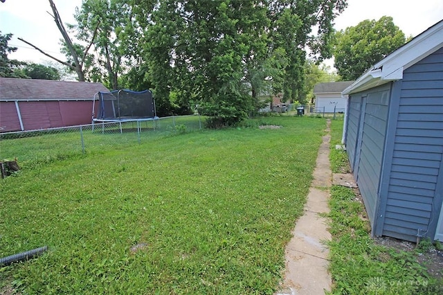 view of yard featuring a trampoline and fence