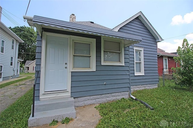 view of front of house featuring a chimney and a front lawn