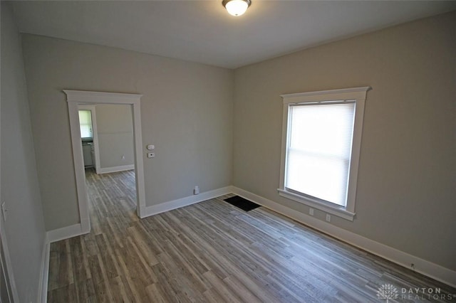 unfurnished room with baseboards and wood finished floors