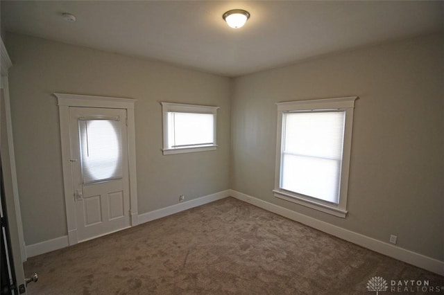 foyer entrance with carpet floors and baseboards