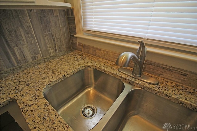 details with a sink and light stone countertops