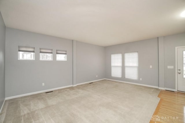 interior space with light wood finished floors, baseboards, and visible vents