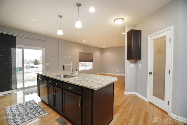 kitchen featuring a sink, visible vents, hanging light fixtures, light wood-type flooring, and dishwasher