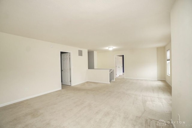 unfurnished room with light carpet, baseboards, and visible vents