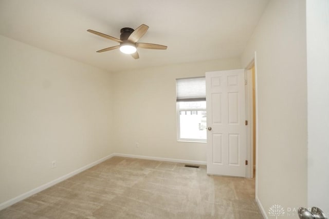 spare room with baseboards, ceiling fan, visible vents, and light colored carpet