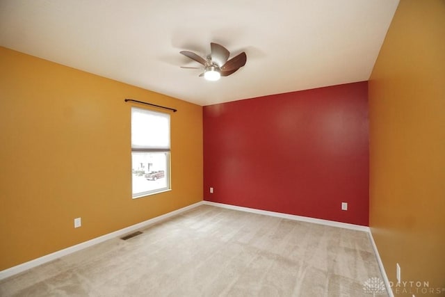 empty room with light carpet, baseboards, and a ceiling fan